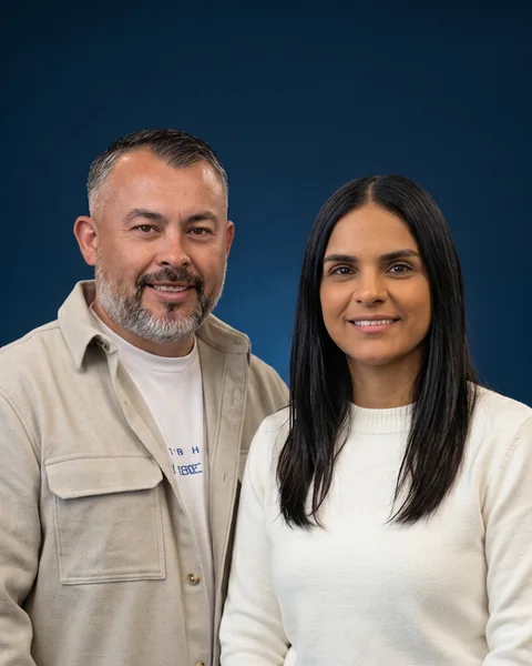Retrato de los dos, sonrientes, sobre fondo azul de estudio